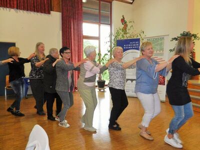 Ausschnitt einer Polonaise mehrer Menschen auf dem Bunten Liedernachmittag in Dellfeld in einem Saal