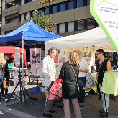 Infostand des Vereins mit Menschen im Gespräch.hh
