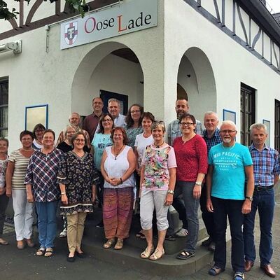 Gruppenbild mit Männers und Frauen vor einem Dorfladen