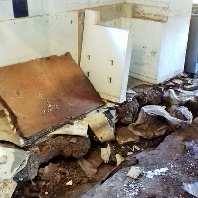 Küche mit zerstörten Möbeln und Boden nach dem ersten Räumungsarbeiten
