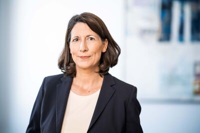 Ein Bild, das eine Frau im Blazer zeigt.