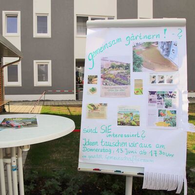 Flipchart im Hof mit Aufruf zum gemeinsamen Gärtnern in der Nachbarschaft