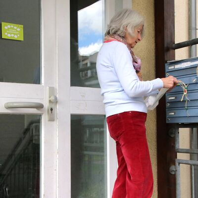 Frau wirft gebastelte Lesezeichen in Briefkasten