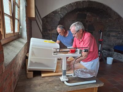 Bild mit zwei Männern, die in einem alten Dorfbackhaus Teige zum Brotbacken vorbereiten