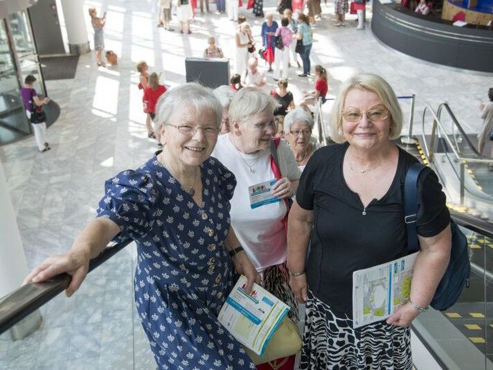 Drei ältere Damen mit Programmheften beim Deutschen Seniorentag