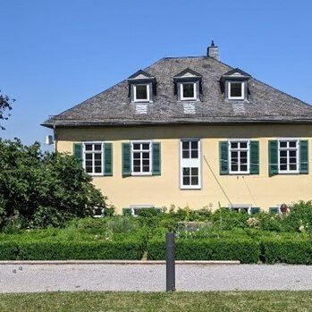 Drei Männer spielen Boule vor dem Pfarrhaus