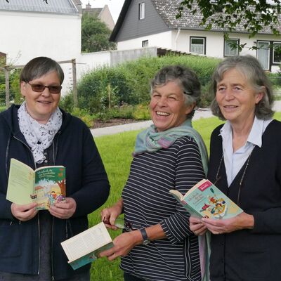 Drei Frauen mit Büchern in der Hand