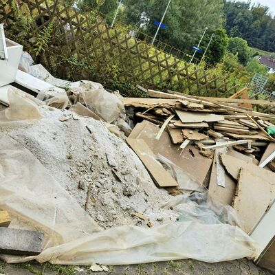 Außenaufnahme Möbelreste, Schutt auf Haufen vor Gartenzaun
