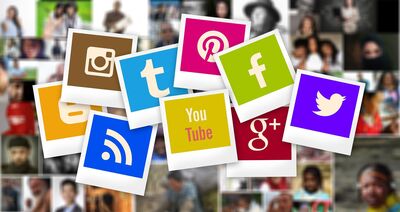 diverse Symbole digitaler Medien vor Pinnwand mit Fotos von Gesichtern