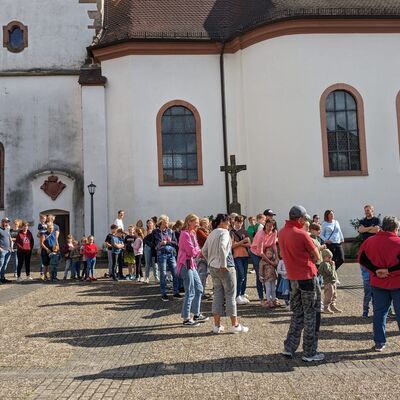 Lange Schlange von Menschen allen Alters vor einem Kirchengebäude