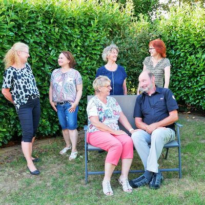 Gruppenfoto des Vereinsvorstandes bei guter Stimmung, Frau und Mann im Vordergrund sitzend, im Hintergrund vier Frauen