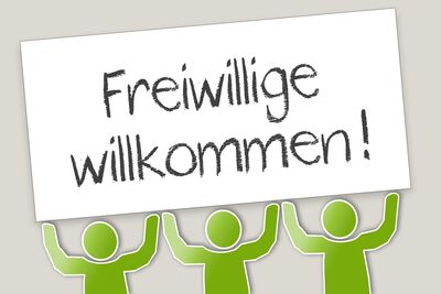 Drei grüne Strickmännchen halten Schild in die Höhe, auf dem steht: Freiwillige willkommen!