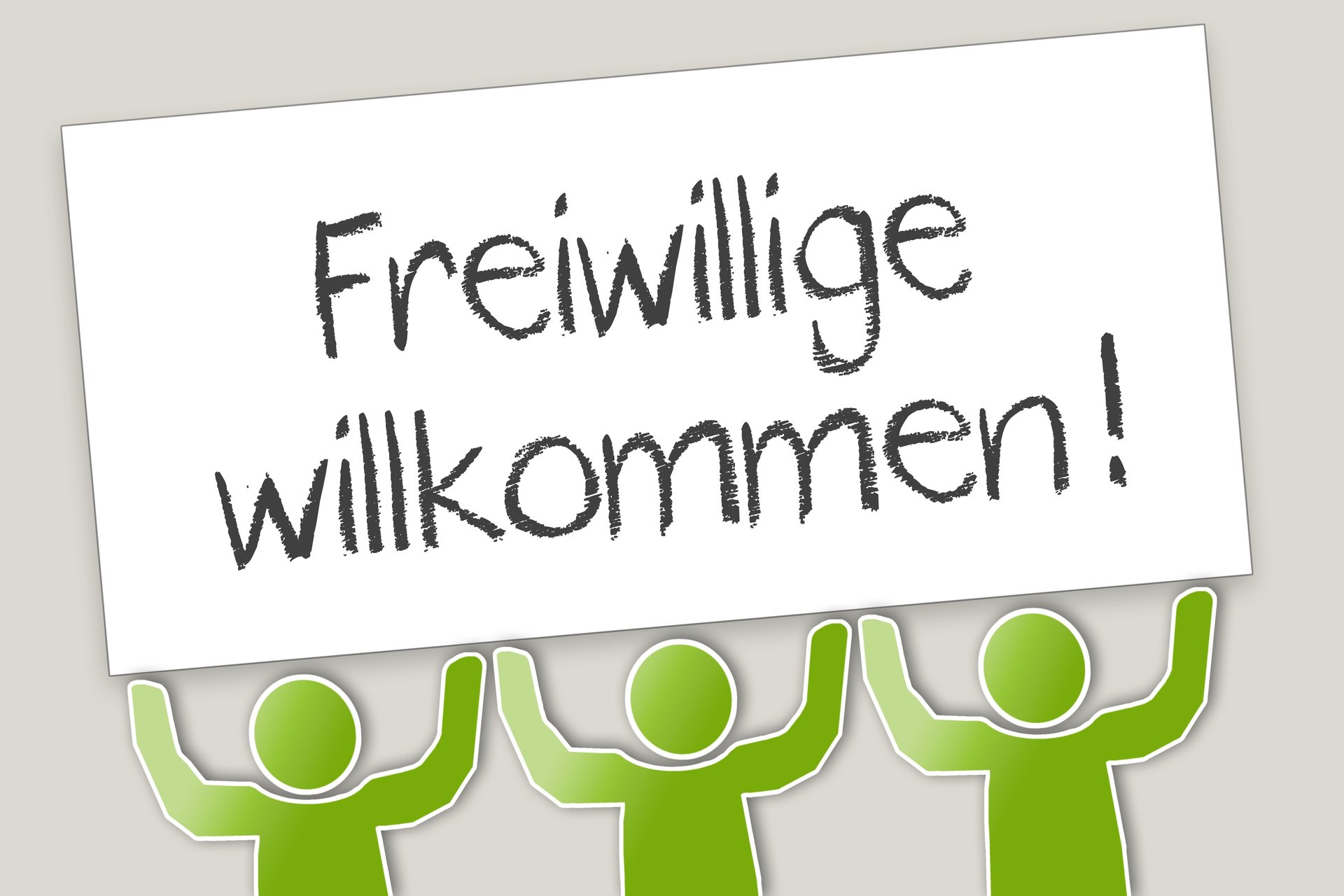 Drei grüne Strickmännchen halten Schild in die Höhe, auf dem steht: Freiwillige willkommen!