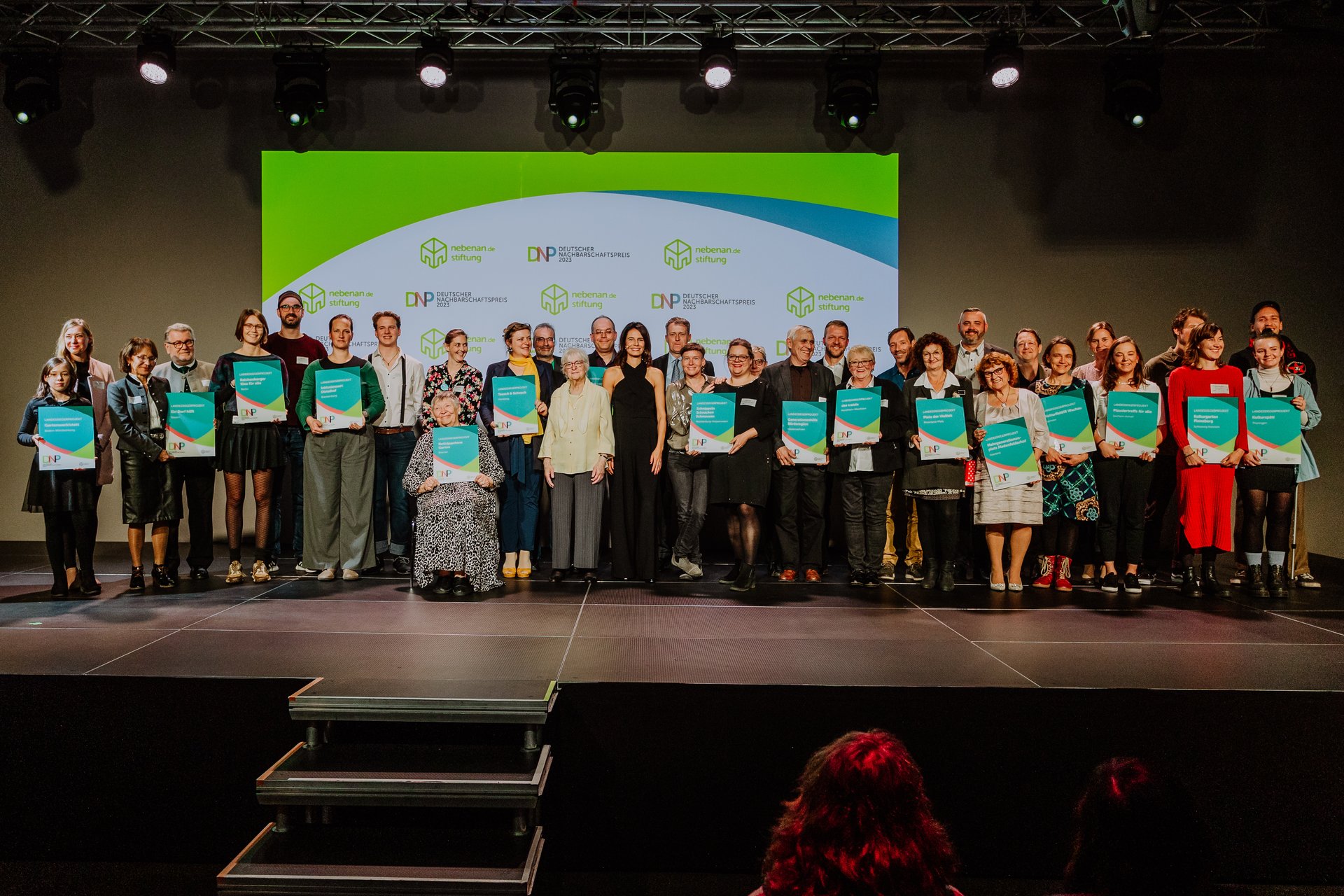 Gruppfenfoto mit vielen Menschen, die eine Preisurkunde in der Hand halten