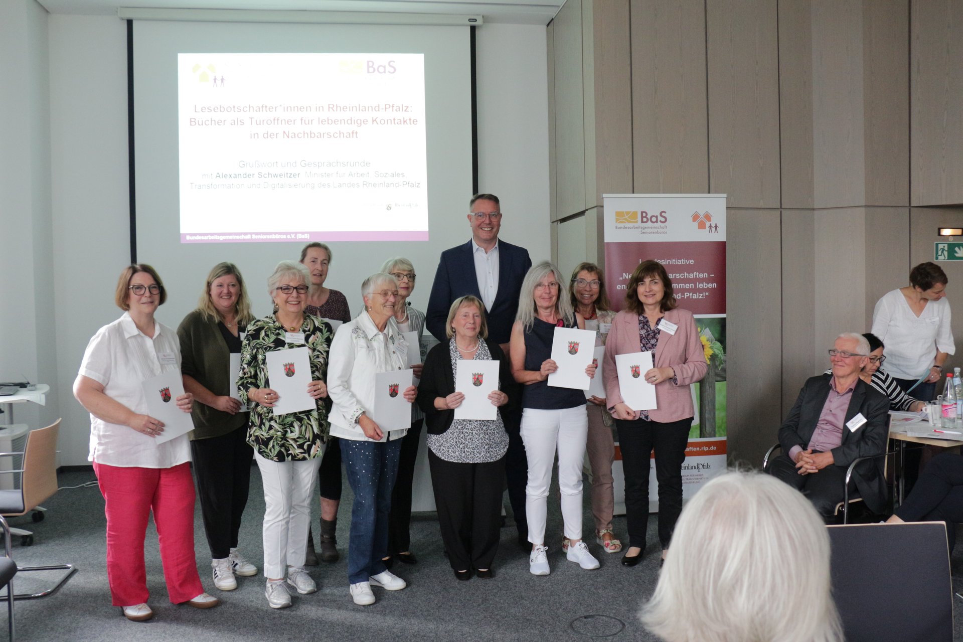 Gruppenbild von Frauen die Urkunden in der Hand halten, mittendrin ein großer Mann in Anzug.